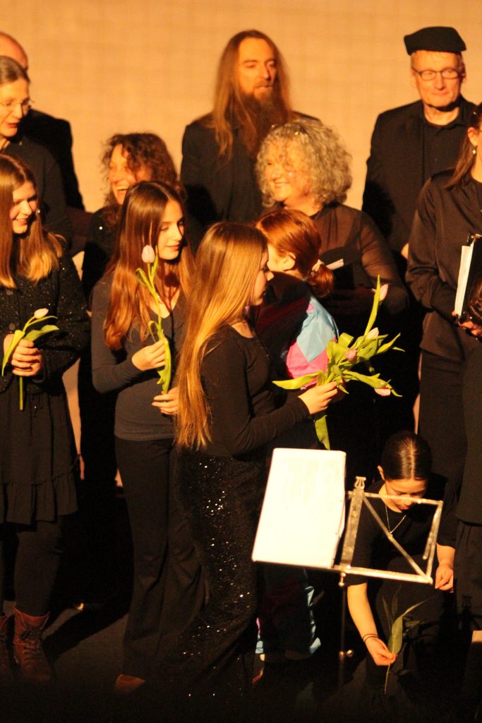Am Ende des Weihnachtskonzertes verteilt der Jugendchor Blumen an die Sängerinnen