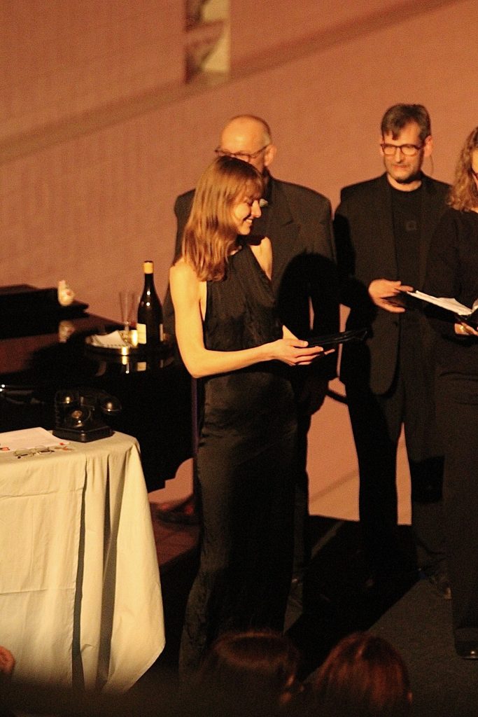 Magdalena Ehlers begrüßt das Publikum im Hallenbad Wolfsburg zum Weihnachtskonzert. Sie steht vor dem Tenor von Chor Cantiamo Wolfsburg